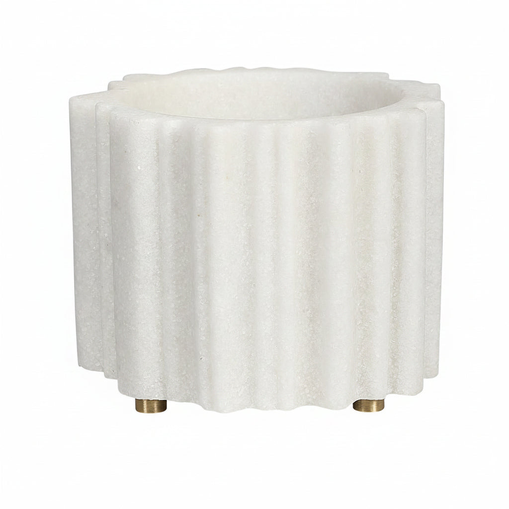 A small, white, textured ceramic cachepot with vertical ridges and gold-colored metal accents on the corners.